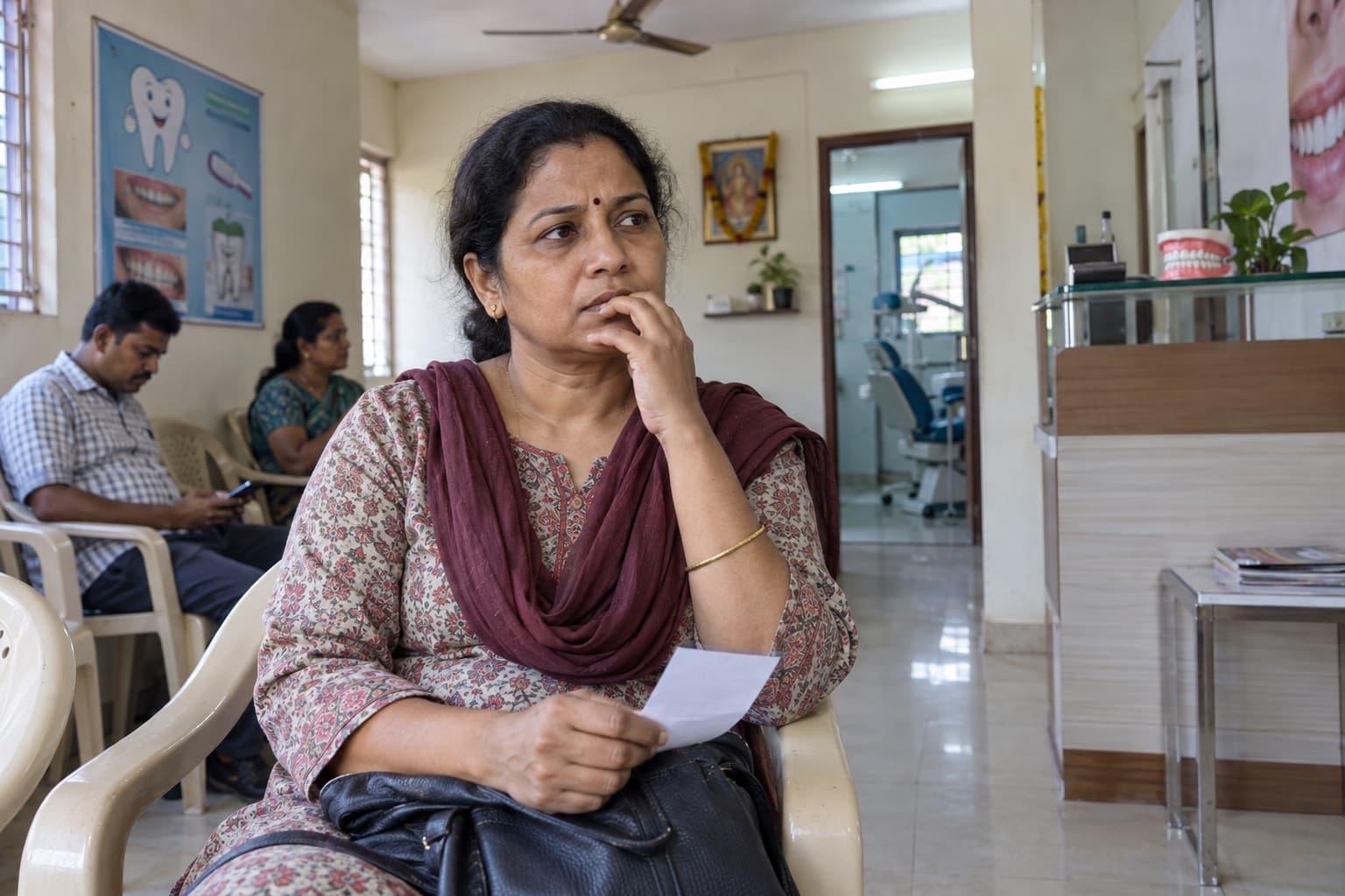 An Indian woman waits thoughtfully at a neighbourhood dental clinic